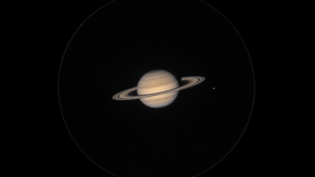Tampilan realistis planet Saturnus melalui eyepiece teleskop amatir memperlihatkan cincin ramping dengan kemiringan 7,5 derajat.